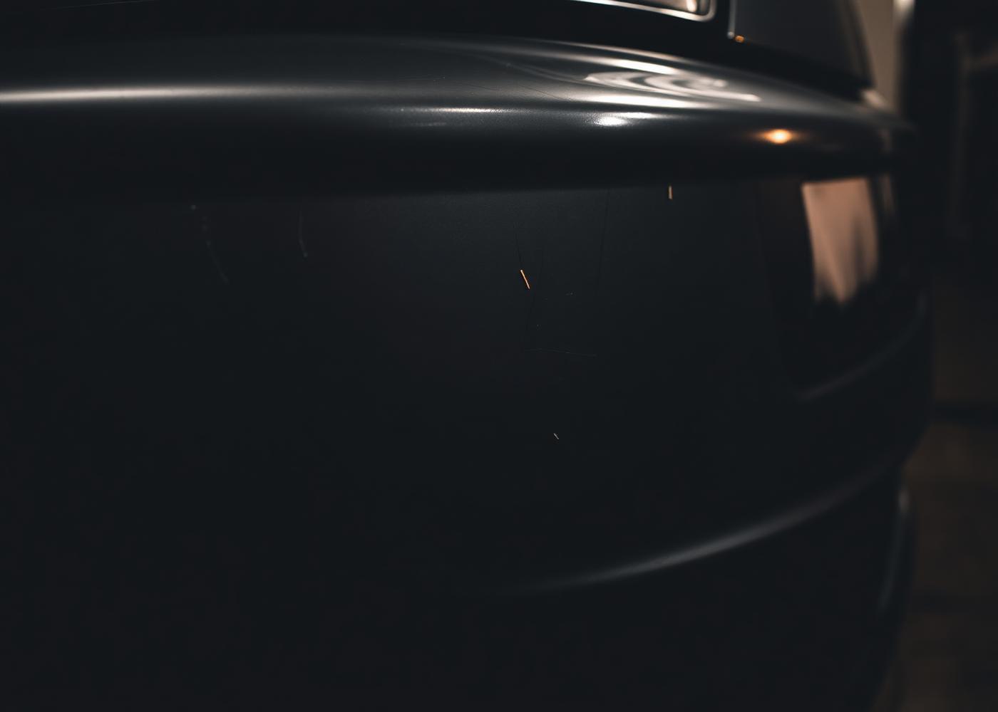 Scratched and scuffed dark car body panel needing dent and scratch repair in Chicago